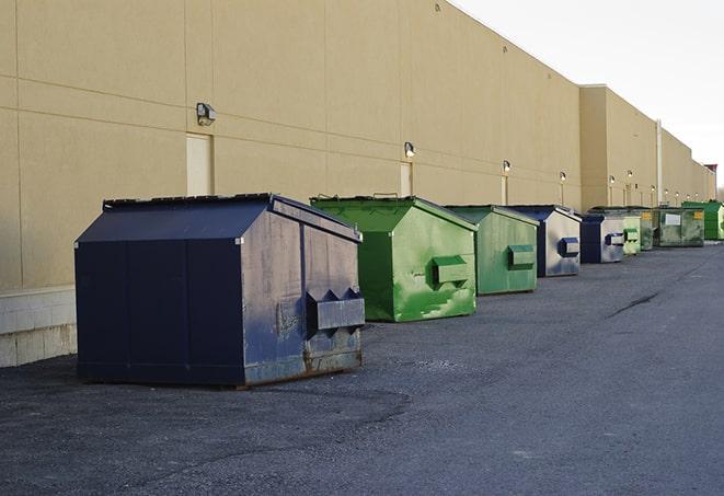 construction workers throw waste into a dumpster behind a building in Anahuac, TX